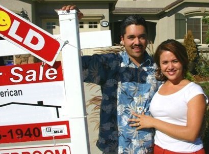 Photo of our clients with their SOLD sign in front of the home they SOLD.